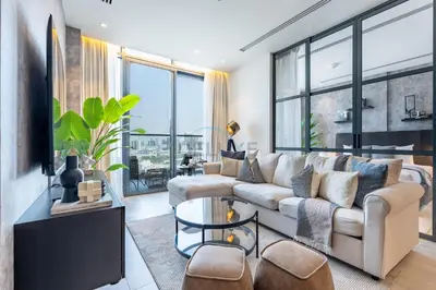a living room with a couch and a table at Close to Dubai Miracle Garden, Dubai Autodrome, and Sports City, with JVT Community Park just steps away - The Ivy, Jumeirah Village Triangle by Deluxe Holiday Homes in Dubai