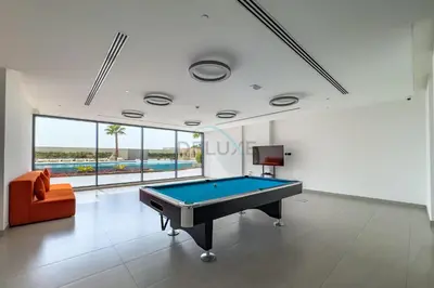 a pool table in a living room with an orange couch at Close to Dubai Miracle Garden, Dubai Autodrome, and Sports City, with JVT Community Park just steps away - The Ivy, Jumeirah Village Triangle by Deluxe Holiday Homes in Dubai