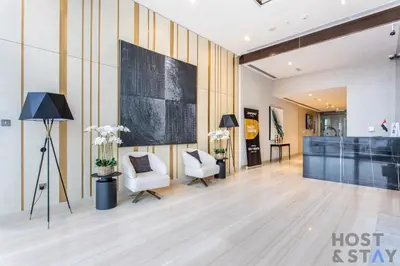 a lobby of a hotel with two chairs and a desk at Cozy Studio in Orchid - Damac Hills Dubai in Dubai