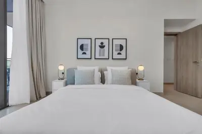 a bedroom with a large white bed with three pictures on the wall at Exclusive Marina Lifestyle with Stunning Views in Dubai