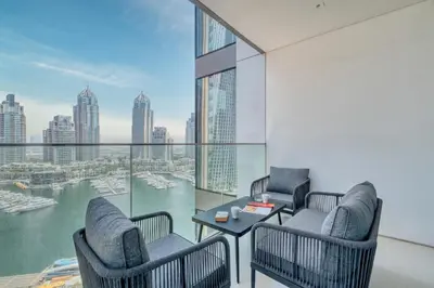 a balcony with chairs and a table and a view of the city at Exclusive Marina Lifestyle with Stunning Views in Dubai