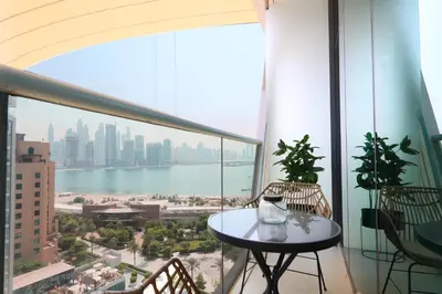 a table on a balcony with a view of the city at Beachfront 1BR Seven Palm Rooftop Pool & Views in Dubai