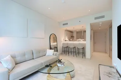 a living room with a couch and a table at Beachfront 1BR Seven Palm Rooftop Pool & Views in Dubai