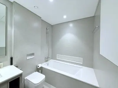 a bathroom with a tub and a toilet and a sink at Skyline Escape 2BR with Balcony Pool & Gym in Dubai