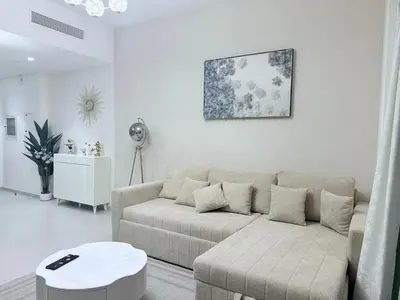 a living room with a couch and a table at Skyline Escape 2BR with Balcony Pool & Gym in Dubai