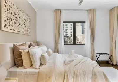 a white bedroom with a large bed with white pillows at 2BR Downtown Dubai 5 Min Walk to Dubai Mall & Burj in Dubai