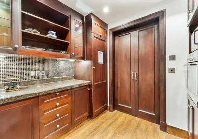 a kitchen with wooden cabinets and a counter top at 2BR Downtown Dubai 5 Min Walk to Dubai Mall & Burj in Dubai