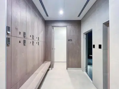 a hallway with wooden doors and a bench in a building at Stylish Coastal Living with Premium Amenities in Dubai