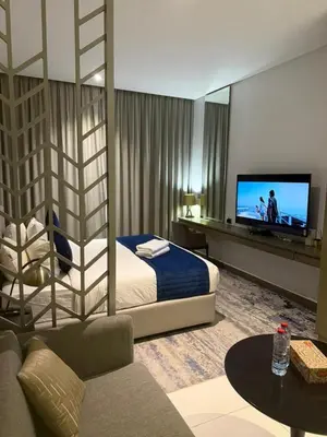 a hotel room with a bed and a tv at Royal Montania by DAMAC Maison Prive in Dubai