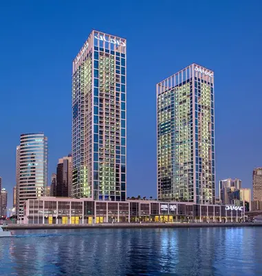 two tall buildings in a city next to the water at Royal Montania by DAMAC Maison Prive in Dubai
