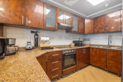 a kitchen with wooden cabinets and a counter top at Luxury 5 Star Newly Furnished 3BR Apartment in Dubai Marina in Dubai