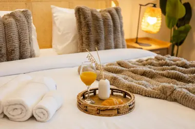a bed with towels and a tray with a glass of orange juice at Luxury 5 Star Newly Furnished 3BR Apartment in Dubai Marina in Dubai