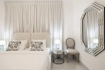 a bedroom with a bed and a mirror and a chair at Elegant 1-BR in Downtown Dubai's Old Town in Dubai