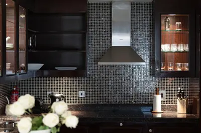 a kitchen with black tiled walls and a counter top at Elegant 1-BR in Downtown Dubai's Old Town in Dubai