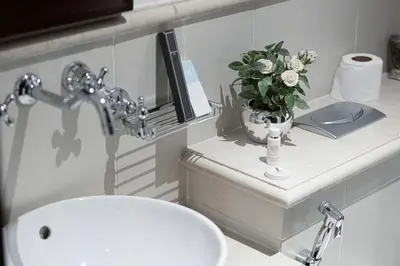 a bathroom with a sink and a vase of flowers on a counter at Elegant 1-BR in Downtown Dubai's Old Town in Dubai