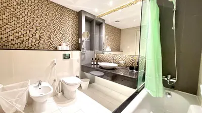 a bathroom with a toilet and a sink and a shower at LUX 1BR 5 Min Walk Dubai Mall - DAMAC Upper Crest in Dubai