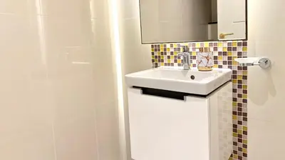 a white bathroom with a sink and a shower at LUX 1BR 5 Min Walk Dubai Mall - DAMAC Upper Crest in Dubai