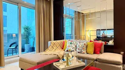 a living room with a couch and a large window at LUX 1BR 5 Min Walk Dubai Mall - DAMAC Upper Crest in Dubai
