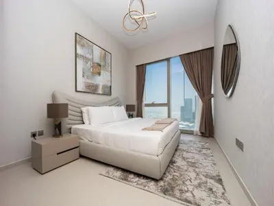 a bedroom with a white bed and a large window at Grande Signature 2BR Burj Khalifa & Dubai Fountain in Dubai
