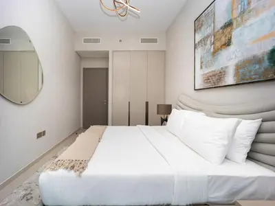 a bedroom with a large white bed and a mirror at Grande Signature 2BR Burj Khalifa & Dubai Fountain in Dubai