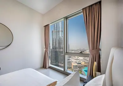 a bedroom with a large window with a view of a city at Grande Signature 2BR Burj Khalifa & Dubai Fountain in Dubai
