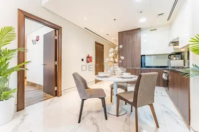a kitchen and dining room with a table and chairs at Stunning 1BR with Panoramic Canal Views, Convenient Downtown Access and Walking Distance to Bus Stop, J One - 1, Business Bay by Deluxe Holiday Homes in Dubai