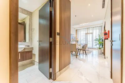 a hallway with a door leading to a dining room at Stunning 1BR with Panoramic Canal Views, Convenient Downtown Access and Walking Distance to Bus Stop, J One - 1, Business Bay by Deluxe Holiday Homes in Dubai
