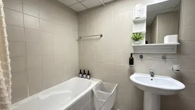 a bathroom with a bath tub and a sink at Studio with Amazing Lake Views in Arch Tower, JLT in Dubai