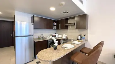 a kitchen with a counter and a refrigerator at Studio with Amazing Lake Views in Arch Tower, JLT in Dubai