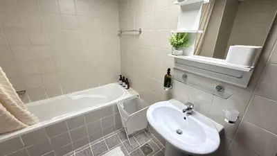 a bathroom with a sink and a bath tub and a sink at Studio with Amazing Lake Views in Arch Tower, JLT in Dubai