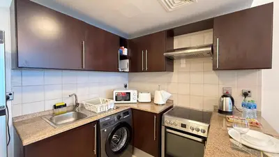 a kitchen with a sink and a washing machine at Studio with Amazing Lake Views in Arch Tower, JLT in Dubai