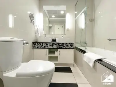 a white bathroom with a toilet and a sink at Luxury 2-Bedroom Apartment, Downtown Skyline Views in Dubai