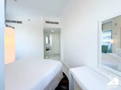 a white bedroom with a mirror and a bed at Luxury 2-Bedroom Apartment, Downtown Skyline Views in Dubai