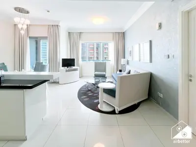 a large white room with a table and chairs at Luxury 2-Bedroom Apartment, Downtown Skyline Views in Dubai