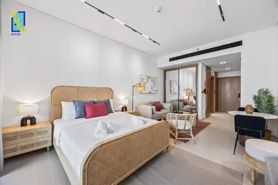 a bedroom with a large bed and a living room at Timeless & Textured Studio w Jacuzzi Trillionaire in Dubai