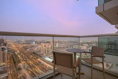 a balcony with a table and chairs and a view of a city at FIRST CLASS Studio Stylish , Prime Location in Dubai