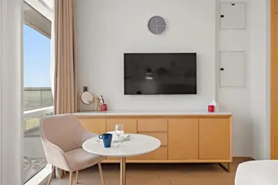 a living room with a table and a tv at FIRST CLASS Studio Stylish , Prime Location in Dubai