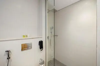 a bathroom with a shower and a phone on the wall at FIRST CLASS Studio Stylish , Prime Location in Dubai