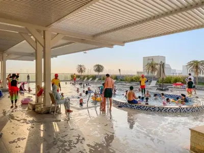 a group of people playing in a swimming pool at FIRST CLASS Studio Stylish , Prime Location in Dubai