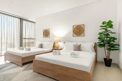 a bedroom with two beds and a potted plant at FIRST CLASS 3BR Comfort and Style , Business Bay in Dubai