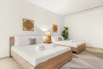 two beds in a room with white walls at FIRST CLASS 3BR Comfort and Style , Business Bay in Dubai