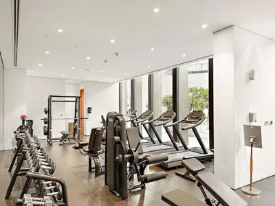 a gym with rows of exercise bikes and treadmills at FIRST CLASS 3BR Comfort and Style , Business Bay in Dubai