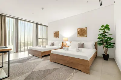 a bedroom with two beds and a large window at FIRST CLASS 3BR Comfort and Style , Business Bay in Dubai