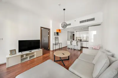 a living room with a couch and a flat screen tv at FIRST CLASS 1BR Marina Skyline Escape in Dubai