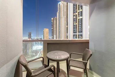 a balcony with chairs and a table and a view of a city at FIRST CLASS 1BR Iconic Burj Khalifa View in Dubai