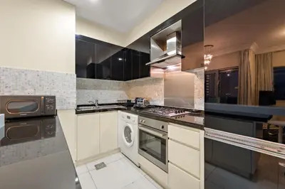 a kitchen with a stove and a washer and dryer at FIRST CLASS 1BR Iconic Burj Khalifa View in Dubai