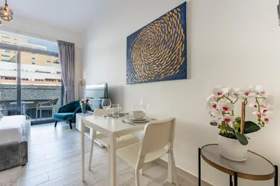 a living room with a white table and chairs at Chic Studio in Vibrant Oxford Residence in Dubai