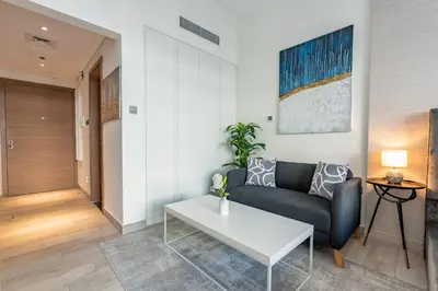 a living room with a couch and a table at Chic Studio in Vibrant Oxford Residence in Dubai