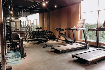 a gym with several tread machines in a room at Modern 1BR in JVC Pool, Gym & Free Parking in Dubai