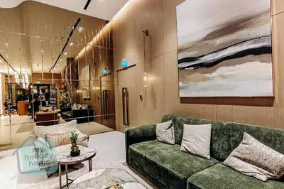 a living room with a green couch and a table at Modern 1BR in JVC Pool, Gym & Free Parking in Dubai